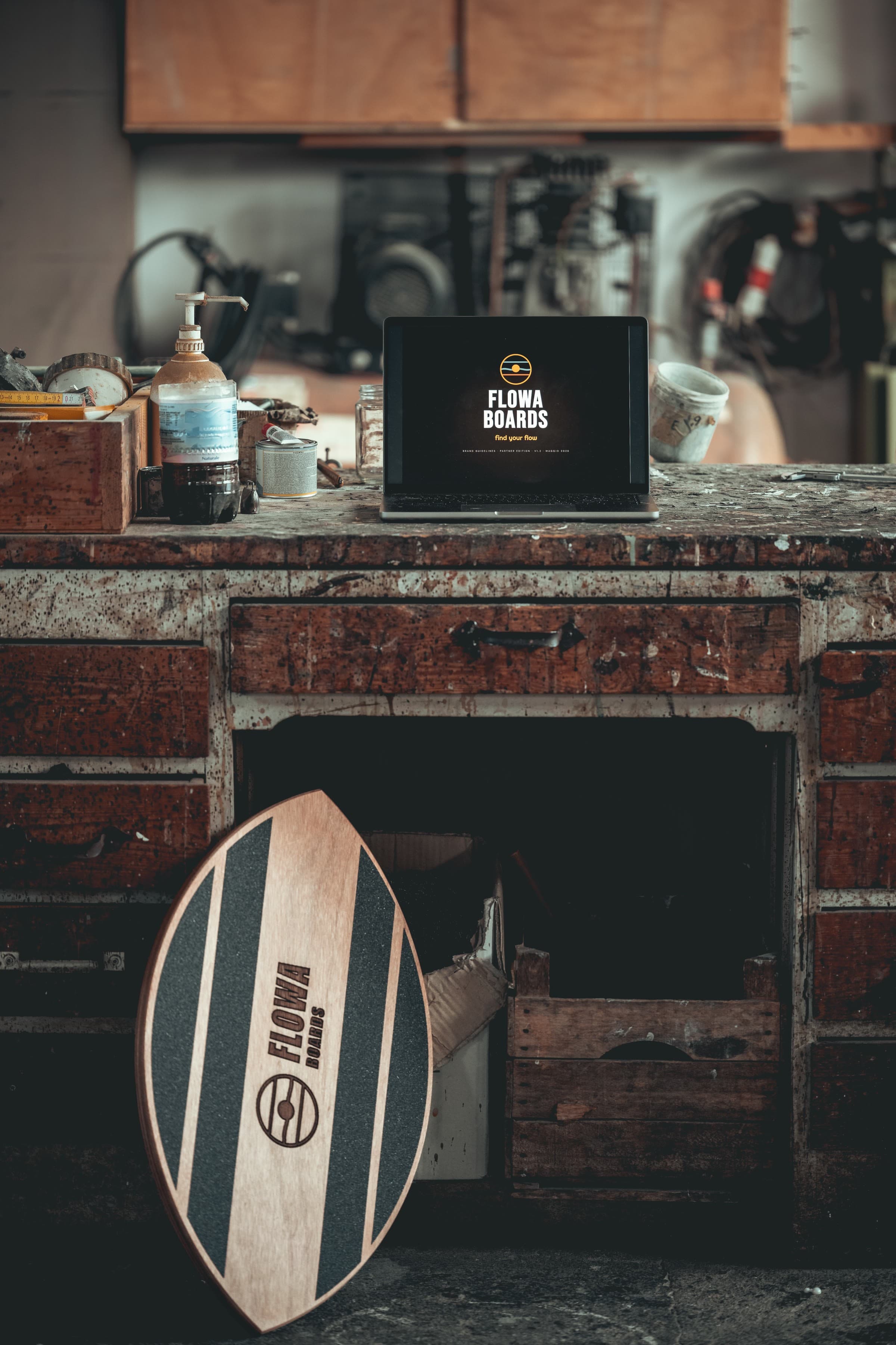 Workshop FlowaBoards: tavola appoggiata al banco da lavoro e laptop che mostra 'find your flow'